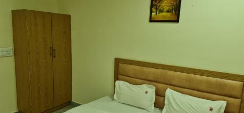 a bedroom with a bed with two white pillows at Vijay Shree Inn in Vellore