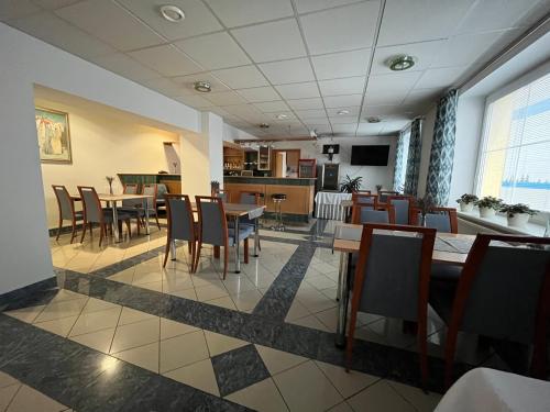 Garni G Hotel Žilina في زيلينا: غرفة طعام مع طاولات وكراسي في مطعم