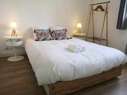 1 dormitorio con 1 cama blanca grande y 2 toallas en Happy Kool - centre ville + wifi + parking privé, en Blois