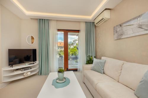 uma sala de estar com um sofá e uma televisão em Apartments Dabinovic em Kotor
