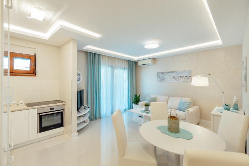 a white living room with a table and a couch at Apartments Dabinovic in Kotor