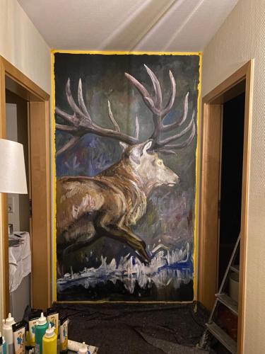 a painting of a deer on the wall of a room at Hotel am Müritz-Nationalpark in Waren