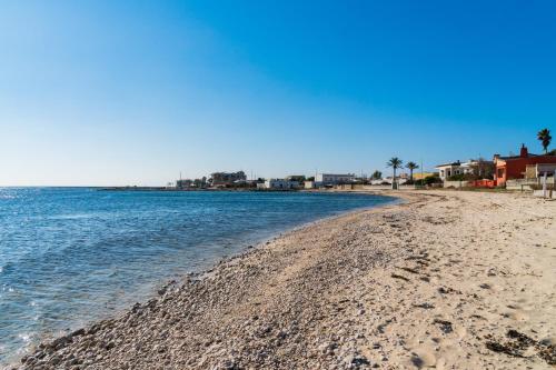 een zandstrand met huizen en de oceaan bij Casa Vacanza Pirandello in Torre Lapillo