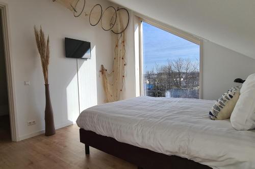 ein Schlafzimmer mit einem großen Bett und einem großen Fenster in der Unterkunft B&B Het Groene Hart in Nieuwkoop