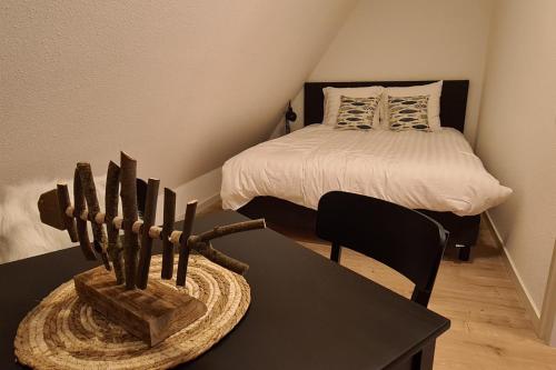 a bedroom with a bed and a black table with a table sidx sidx at B&B Het Groene Hart in Nieuwkoop