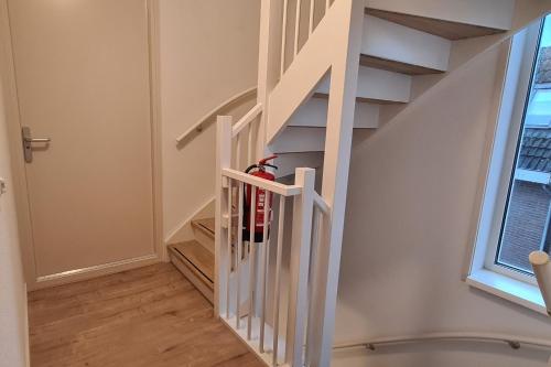 a spiral staircase with white railings and a window at B&B Het Groene Hart in Nieuwkoop