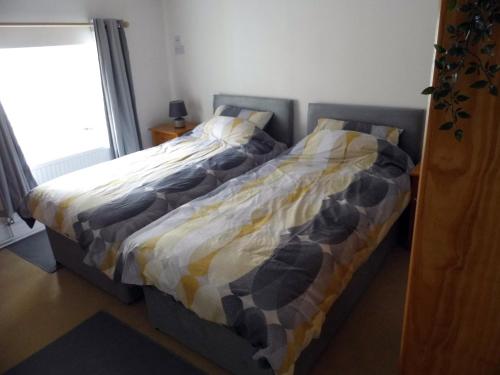 dos camas sentadas una al lado de la otra en un dormitorio en Acer Cottage, en Bampton