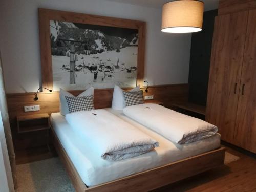 a bedroom with a large bed with white sheets and pillows at Haus Rita in Berwang