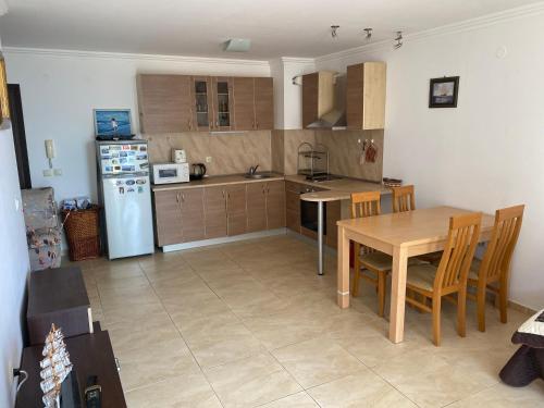 a kitchen with a table and a white refrigerator at Manastira-2 (A-3) in Sveti Vlas