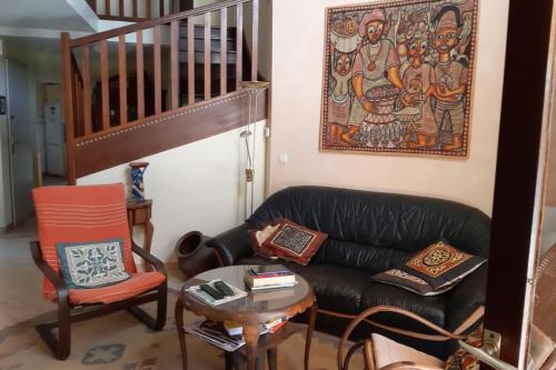 sala de estar con sofá de cuero negro y mesa en Maison Du Soleil Quiet And Central, en Les Angles