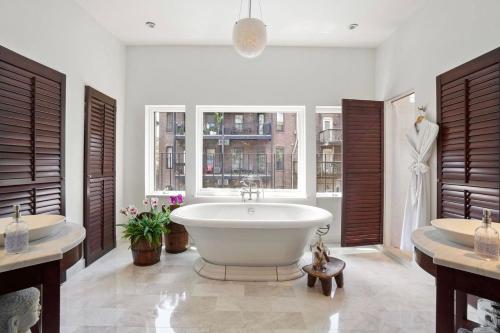 uma casa de banho com 2 lavatórios e uma grande banheira em Clarendon Square em Boston