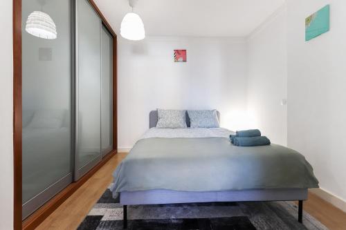 a bedroom with a bed in a white room at Lisbon Flower 360º - Your Lovely Flat with Pool and Parking in Lisbon