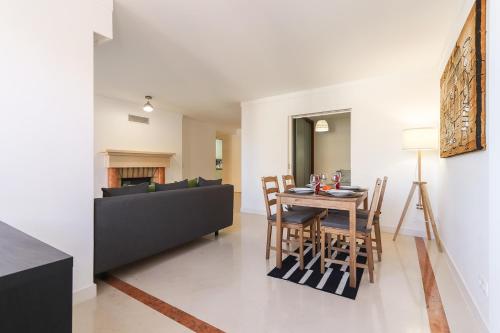 a living room with a table and a couch at Lisbon Flower 360º - Your Lovely Flat with Pool and Parking in Lisbon