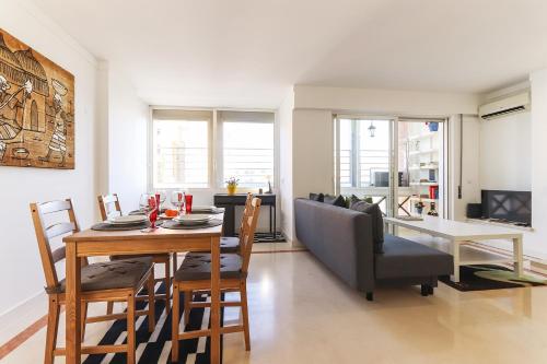 a dining room and living room with a table and chairs at Lisbon Flower 360º - Your Lovely Flat with Pool and Parking in Lisbon