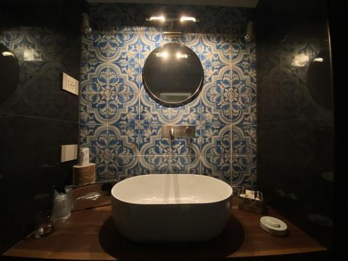 a bathroom with a large tub and a mirror at Hotel Foresteria Baglio Della Luna in San Leone