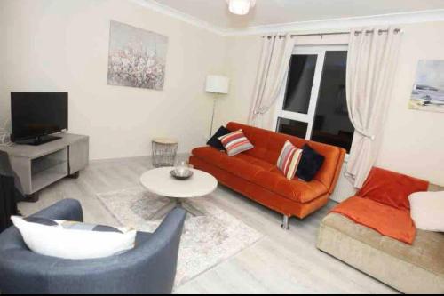 a living room with an orange couch and a table at “John Bs” 1 Bedroom Apartment in Ardara in Ardara