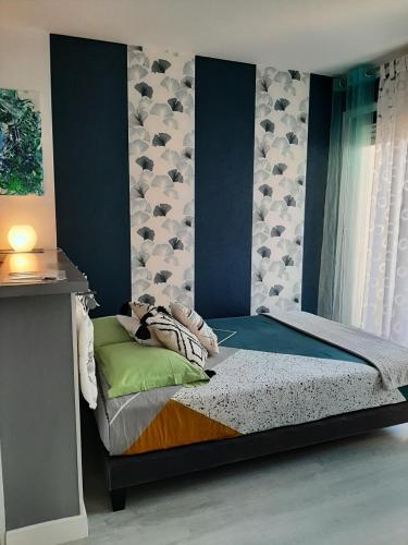une chambre avec un lit avec un mur bleu dans l'établissement Appartement T1 Hyper Centre avec Balcon, à Bordeaux
