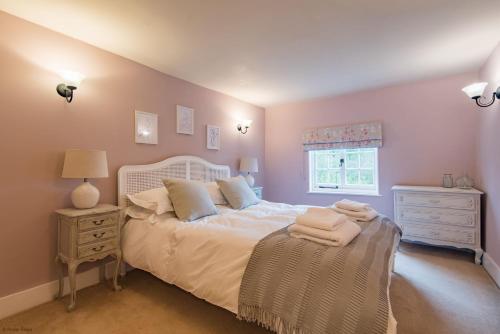 1 dormitorio con cama blanca y ventana en Old Post Office sleeps 4 by Bloom Stays, en Faversham