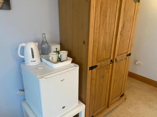 a small refrigerator with a coffee maker on top of it at Lakeland Snug in Keswick