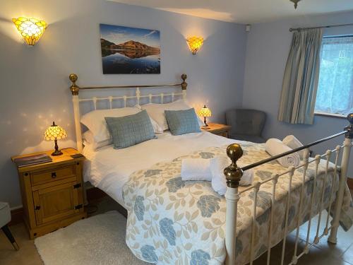 a bedroom with a bed with a white bedspread at Lakeland Snug in Keswick