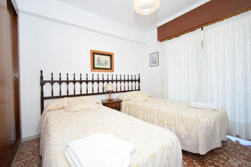 a bedroom with two beds and a window at Mariscal I - Fincas Arena in Benidorm