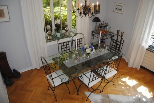 a dining room with a glass table and chairs at Exklusive Villa am Wald mit Garten, Waldzugang und Sauna in Solingen