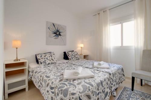 1 dormitorio con 1 cama, 1 silla y 1 ventana en 3 bedroom apartment with private rooftop terrace, en Nerja