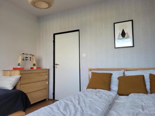 a bedroom with a bed and a dresser and a door at Apartmán Spa Šumava in Zdíkov