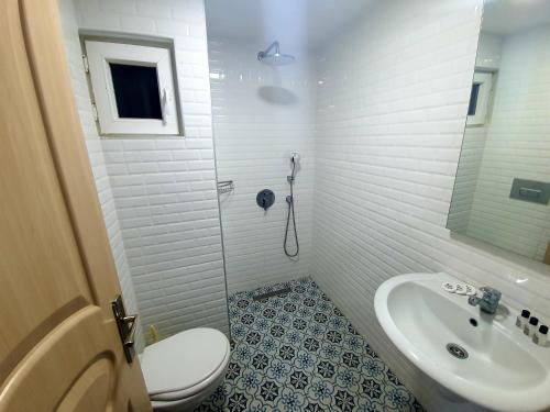a white bathroom with a toilet and a sink at Ressa Apart in Marmaris