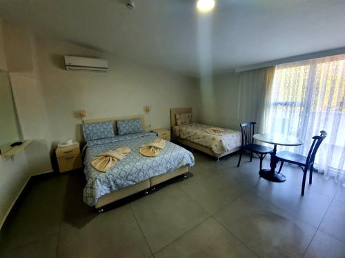 a bedroom with two beds and a table and a table sidx sidx sidx at Ressa Apart in Marmaris