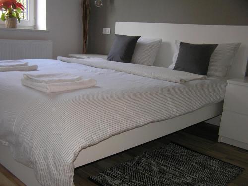 een groot wit bed met 2 handdoeken erop bij 2LKT studio apartman in Zagreb