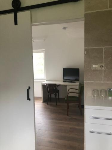 a kitchen with a table and a desk with a computer at B&B Het Zonnehuis Boxtel in Boxtel