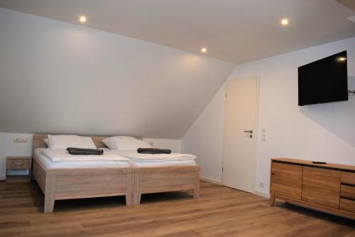 een slaapkamer met een bed en een flatscreen-tv bij Ferienhaus Hanni in Geeste