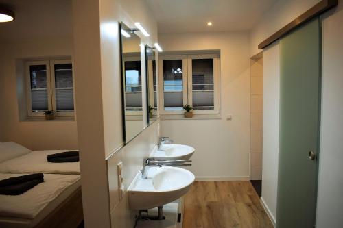 a bathroom with two sinks and a bed at Ferienhaus Hanni in Geeste