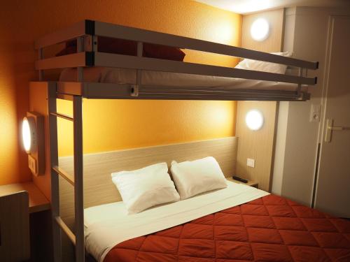 a bedroom with a bunk bed with white pillows at Premiere Classe Saumur in Saumur