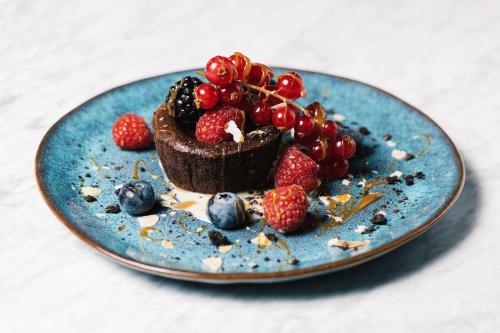 a blue plate with a dessert with berries on it at Alex Maastricht in Maastricht