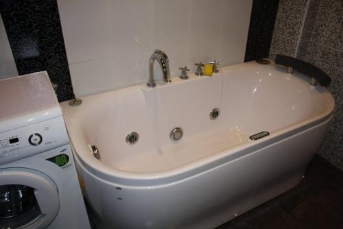 a white bath tub in a bathroom with a washing machine at Vacation House in Truskavets