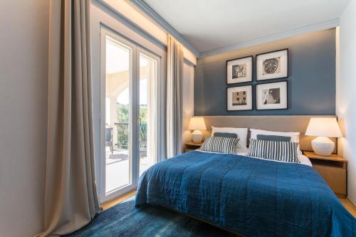 a bedroom with a blue bed and a large window at Villa Sunrise in Gornji Brgat