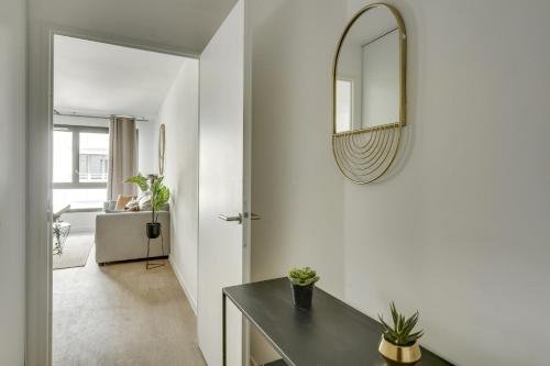 a white room with a mirror and a table at Superbe appartement avec balcon et parking proche Paris in Saint-Denis