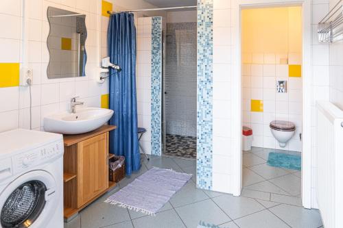 a bathroom with a sink and a washing machine at Chalet "Knusperhäuschen" in Murau