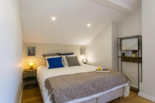 1 dormitorio con 1 cama grande con almohadas azules en Pearl of Belem, en Lisboa