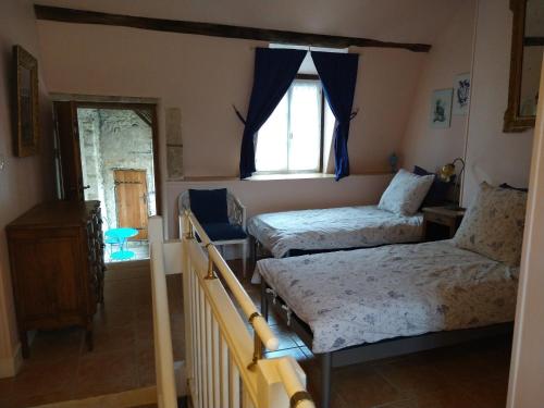 a bedroom with two beds and a window at Le Passage in La Charité-sur-Loire