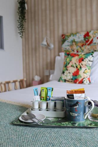 a tray with cups and other items on a bed at Porth Beach Hotel in Newquay