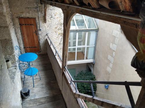 a balcony with a blue table and a window at Le Passage in La Charité-sur-Loire