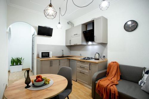 a kitchen and a living room with a table and a couch at Квартира в центре на соборной apartment in sobornaya st in Mykolaiv