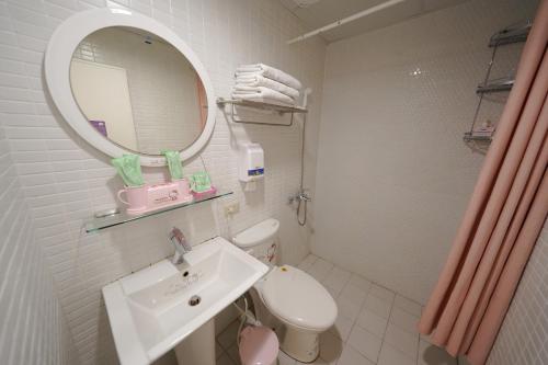 a bathroom with a sink and a toilet and a mirror at 安蘭居旅店 An Lan Jie Hotel in Chiayi City