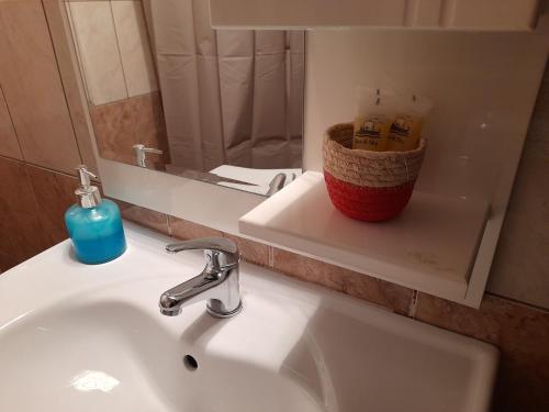 a bathroom sink with a mirror and a basket on it at Dimitra in Dháfni