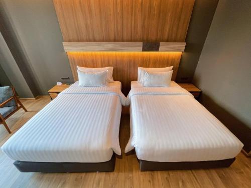 two beds sitting next to each other in a room at The Teak Hotel in Mae Sot