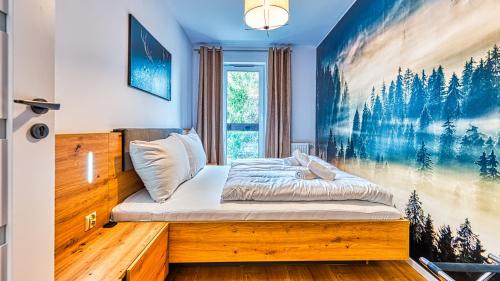 una camera da letto con un letto e un dipinto sul muro di Apartament Przy Wyciągu 1 - 5D Apartamenty a Świeradów-Zdrój