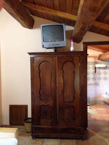 a tv on top of a wooden cabinet with a television on top at Agriturismo Capriccio Di Giove in Cansano